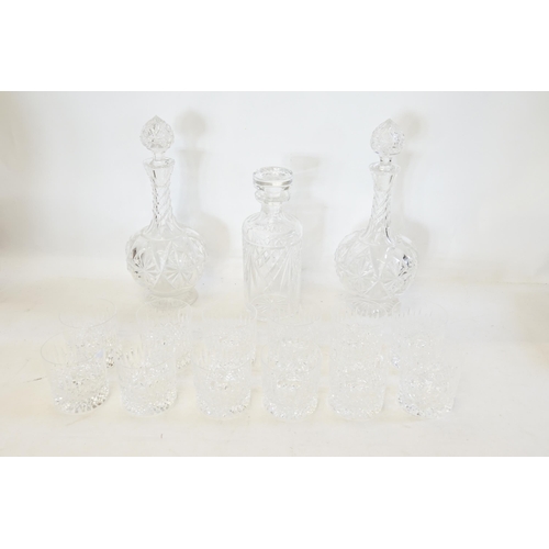 558 - A Set of 12 Glass Hobnail Whiskey Tumblers along with three Decanters.