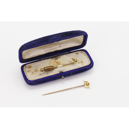 115 - Two cased 15ct gold stick pins, with a button.