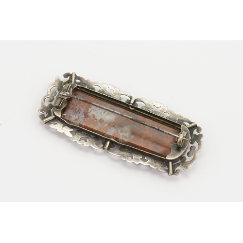 149 - A Scottish pebble brooch, set with various agates, in a symmetrical form. Silver floral mount. Width... 