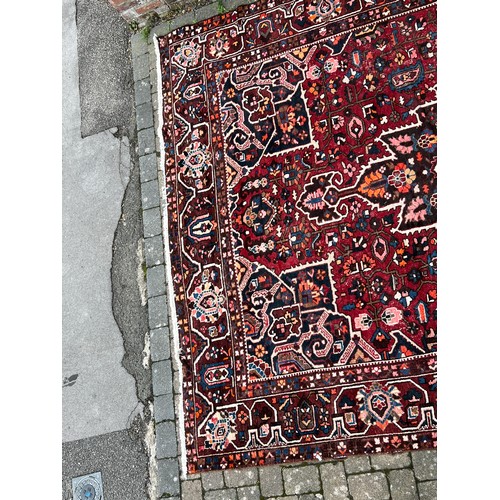 482 - A Rust Blue & Red Ground Floral Medallioned Border Edged Gul & Trefoil Persian Carpet. Measuring: (B... 