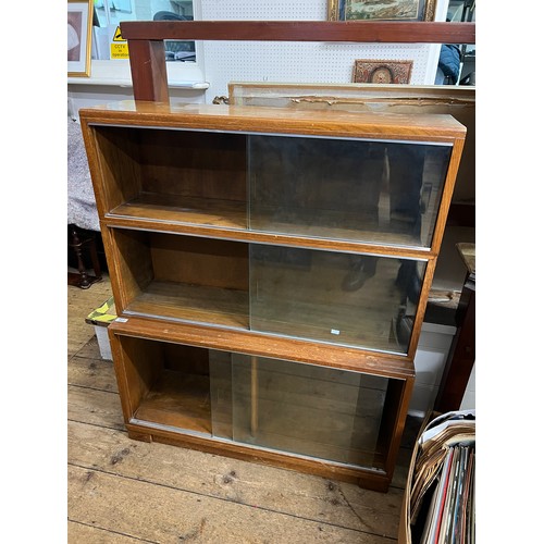 464 - A Three Tiered Minty Bookcase with Glass Sliding Doors. Measuring: 90cms across x 109cms high.