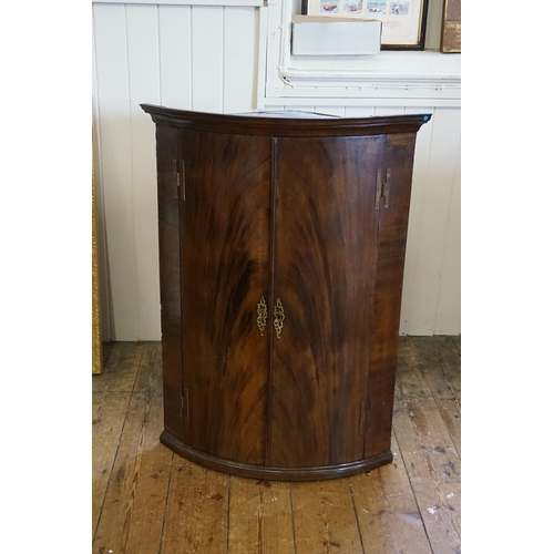 580 - A Georgian Flame Figured Mahogany Bow Front Corner Cupboard with 