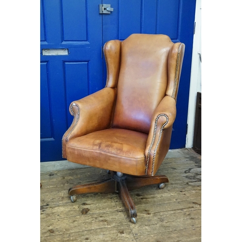 610 - A Leather Seated Queen Anne design Semi-Winged Roll over armed Swivel Chair with Brass Studs. (AF).