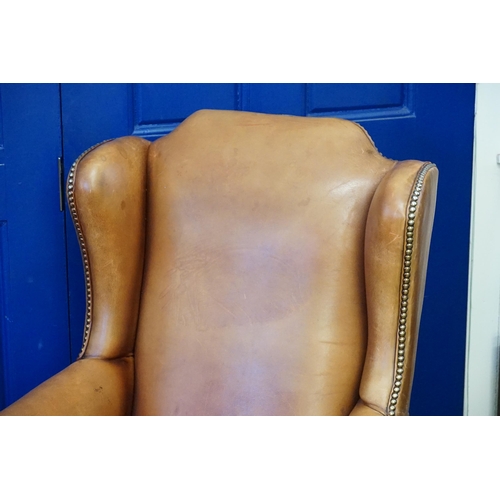 610 - A Leather Seated Queen Anne design Semi-Winged Roll over armed Swivel Chair with Brass Studs. (AF).