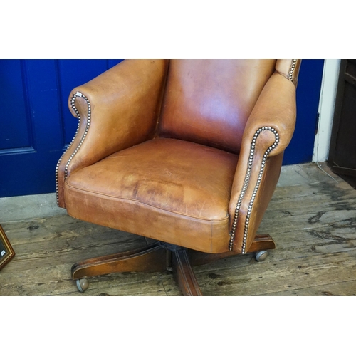 610 - A Leather Seated Queen Anne design Semi-Winged Roll over armed Swivel Chair with Brass Studs. (AF).