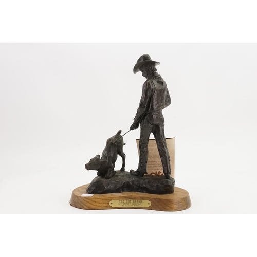 712 - A Richard Muno painted & Cast Sculpture depicting a Cowboy branding a calf entitled 