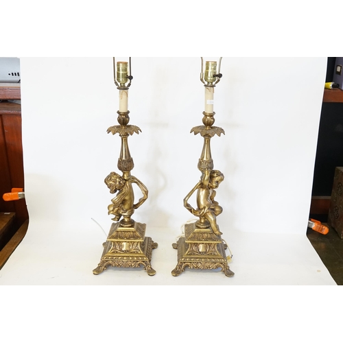 692 - A Pair of Cupid Table Lamps with Rococo decoration standing on square bases. Measuring: 60cms high.