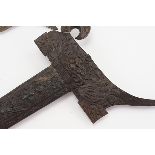 329 - A Malaysian Kris decorated with the lion god of a war contained in a carved scabbard with floral dec... 