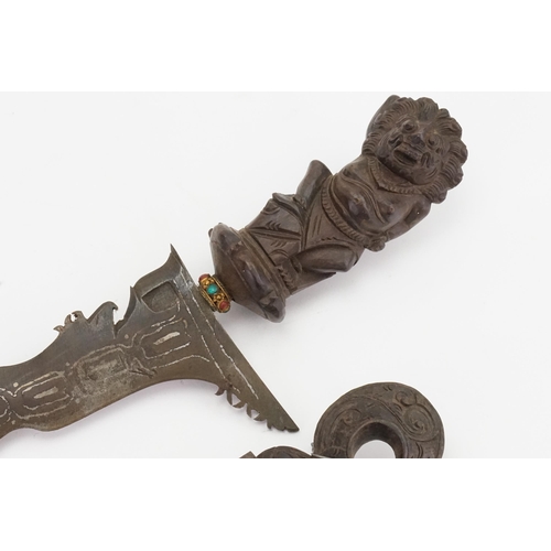 329 - A Malaysian Kris decorated with the lion god of a war contained in a carved scabbard with floral dec... 