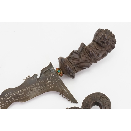 329 - A Malaysian Kris decorated with the lion god of a war contained in a carved scabbard with floral dec... 