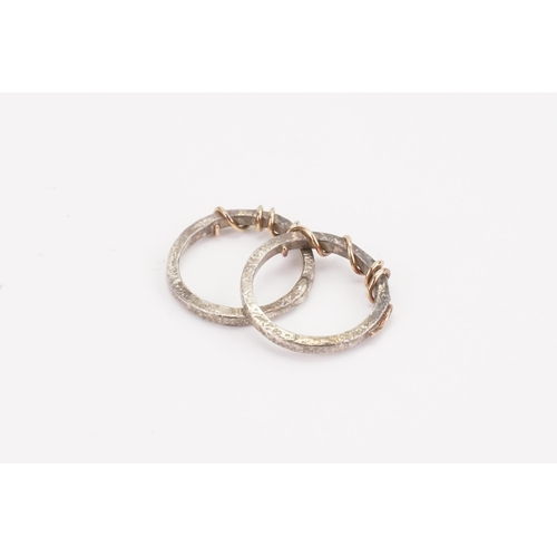 102 - A pair of silver and gold coloured wedding bands, with wire decoration. Weight 5g.