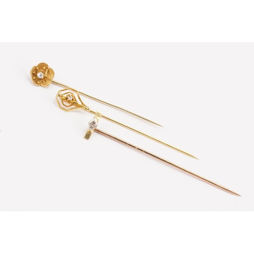 158 - A 10ct gold diamond set stick pin, along with a floral diamond stick pin and one other diamond stick... 