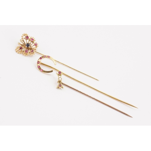 164 - A ruby and sapphire set butterfly stick pin, along with a horse shoe ruby set stick pin, and one oth... 