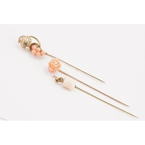 167 - Three carved light coral stick pins, designed as flowers.