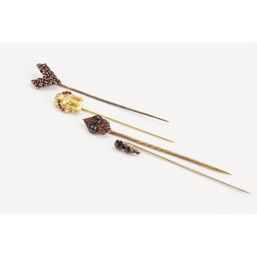 175 - A 14ct gold garnet set stick pin, along with three others.