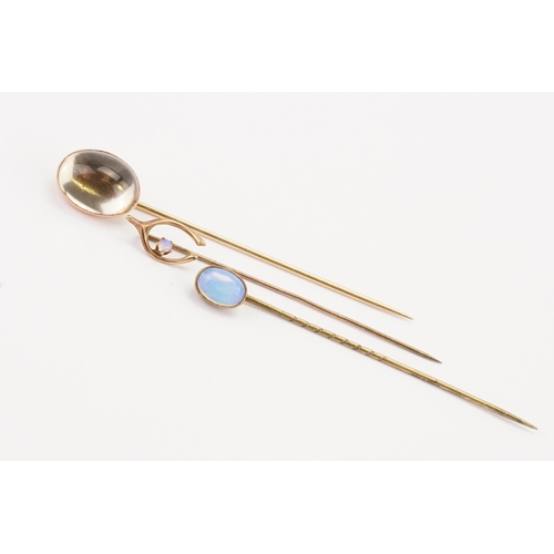 183 - A 14ct dome effect stick pin, along with two moon stone set stick pins.