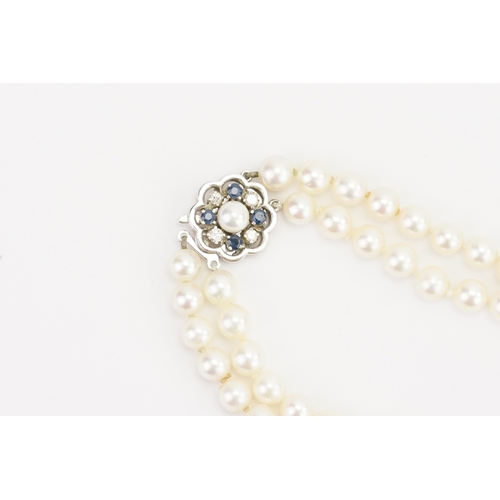 116 - A JKA Köhle marked double string of pearls, with a 14ct white gold diamond & sapphire clasp. Length ... 