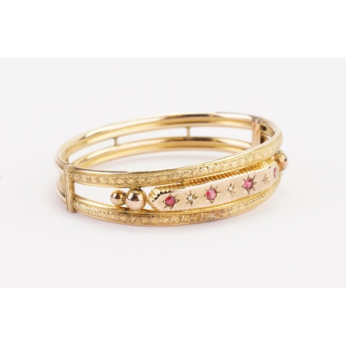 119 - A Victorian 9ct gold diamond and ruby set bangle. Weight 10.8g.