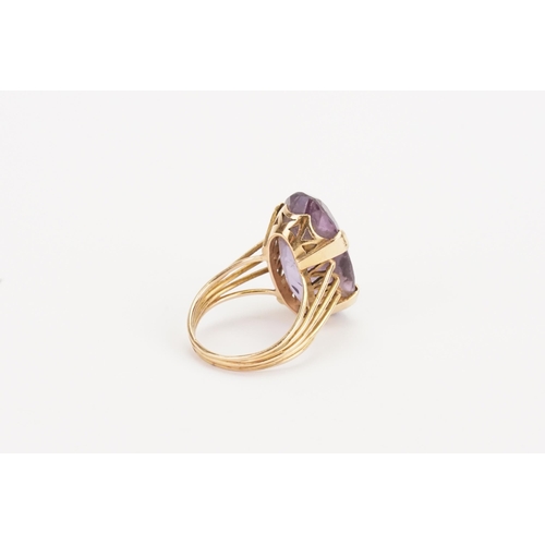 61 - A higher than 9ct gold amethyst ring, set with a large marquise amethyst (25.9mm x 14.6mm). Weight 9... 