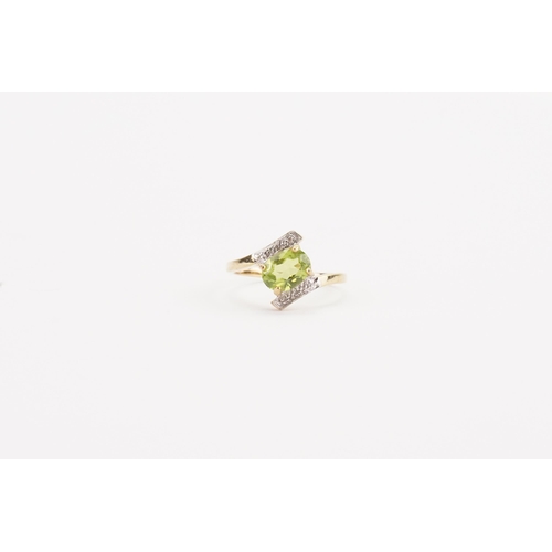 63 - A 9ct gold green stone and diamond set ring, in the cross over design. Weight 2.3g. Size N.