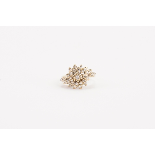 65 - A 9ct gold diamond set ring, in the swirl formation. Set with approximately 29 diamonds. Weight 4g. ... 