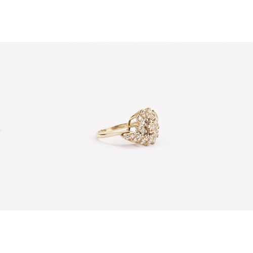 65 - A 9ct gold diamond set ring, in the swirl formation. Set with approximately 29 diamonds. Weight 4g. ... 