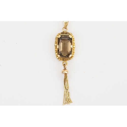 114 - A unmarked smoky quartz pendant hung with a tassel. Hung on a gold Chain. Weight 5g.