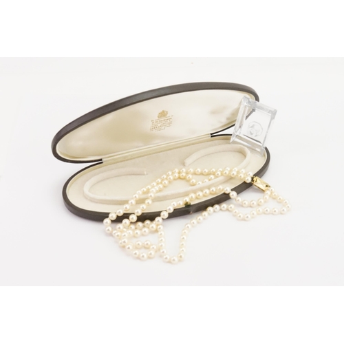 85 - A double strand of Garrard pearls, set with a 18ct yellow gold and diamond set clasp. Set with 59 an... 