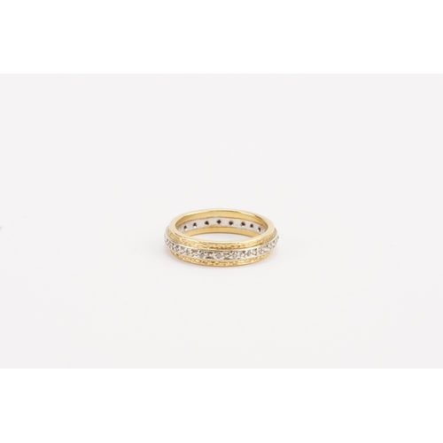 82 - A high caret diamond set eternity band in yellow and gold. Weight 6g. Size O.