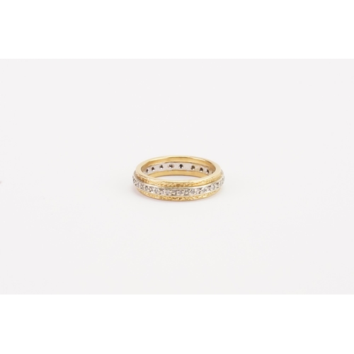 82 - A high caret diamond set eternity band in yellow and gold. Weight 6g. Size O.