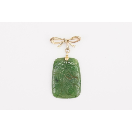 142 - A 9ct gold mounted nephrite brooch. With carved design. Weight 24.1g. Size 48.5mm x 35mm.