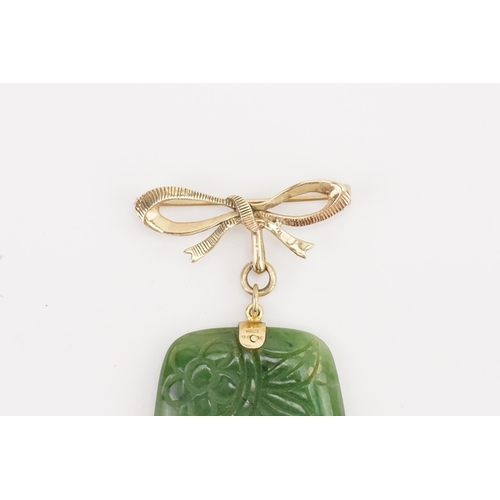 142 - A 9ct gold mounted nephrite brooch. With carved design. Weight 24.1g. Size 48.5mm x 35mm.