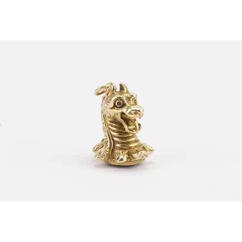 143 - A 9ct gold ruby eye dragon seal, with quartz base. Weight 33g.