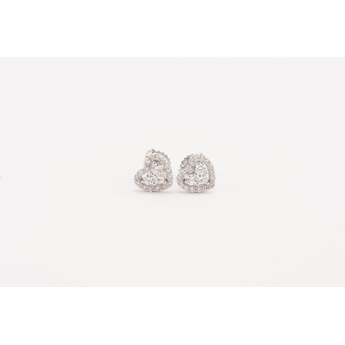 74 - A pair of 18ct white gold diamond set earrings, in the heart design. The heart is created by two bri... 