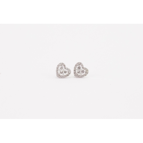 74 - A pair of 18ct white gold diamond set earrings, in the heart design. The heart is created by two bri... 