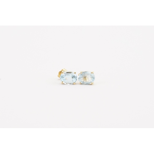 76 - A pair of 18ct yellow and white gold aquamarine earrings, in the oval form. Size approximately 9mm x... 