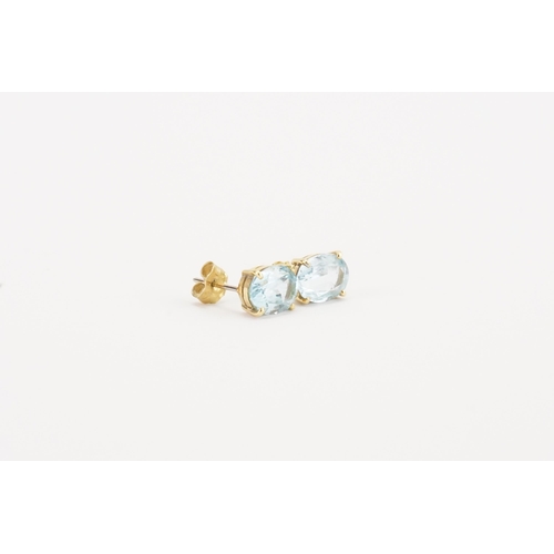 76 - A pair of 18ct yellow and white gold aquamarine earrings, in the oval form. Size approximately 9mm x... 