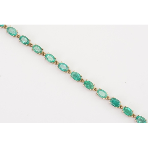 77 - A 9ct gold emerald tennis bracelet, set with twenty two oval cut 6mm x 4mm emeralds. Length 19.5cm. ... 