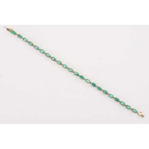 77 - A 9ct gold emerald tennis bracelet, set with twenty two oval cut 6mm x 4mm emeralds. Length 19.5cm. ... 