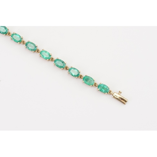 77 - A 9ct gold emerald tennis bracelet, set with twenty two oval cut 6mm x 4mm emeralds. Length 19.5cm. ... 