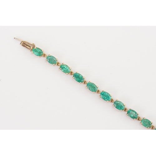 77 - A 9ct gold emerald tennis bracelet, set with twenty two oval cut 6mm x 4mm emeralds. Length 19.5cm. ... 