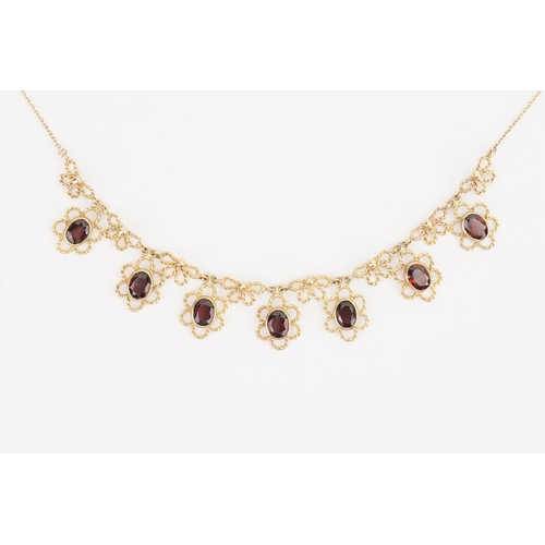 150 - A 9ct Gold Circa 1970s Oval Garnet & Bow design Necklace set with seven oval Garnets. Measuring: 415... 