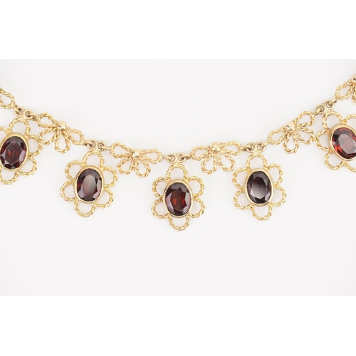 150 - A 9ct Gold Circa 1970s Oval Garnet & Bow design Necklace set with seven oval Garnets. Measuring: 415... 