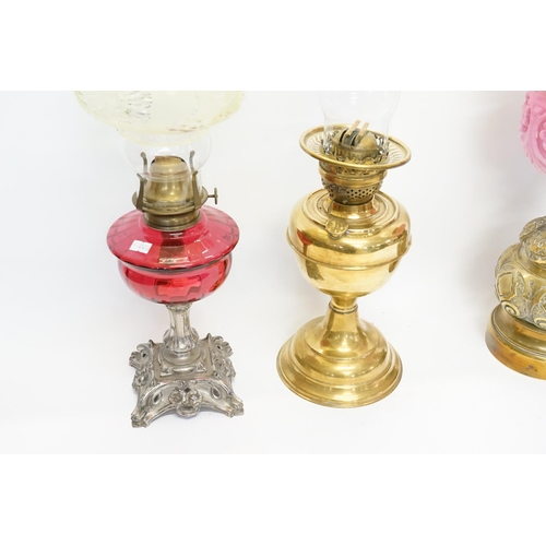 994 - A Victorian Brass embossed Oil Lamp with patent mechanism, one other in Ruby Glass & a stamped Brass... 