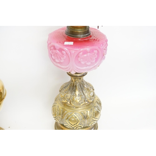 994 - A Victorian Brass embossed Oil Lamp with patent mechanism, one other in Ruby Glass & a stamped Brass... 