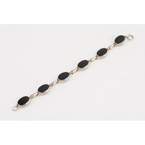 184 - A silver and onyx set bracelet. Weight 21g.