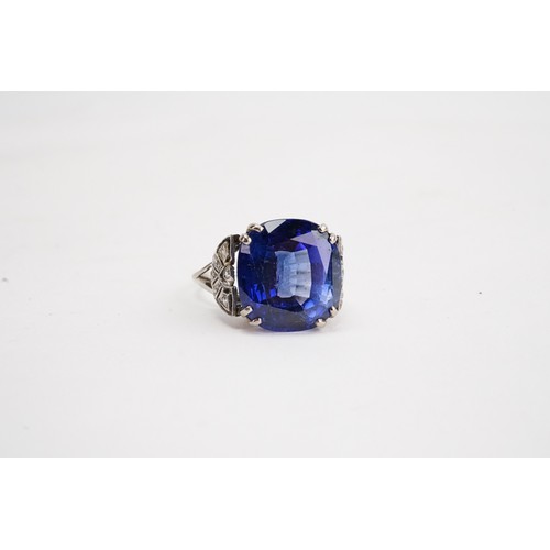 124 - A large synthetic sapphire stone in white coloured metal surrounded by paste stones.               
... 