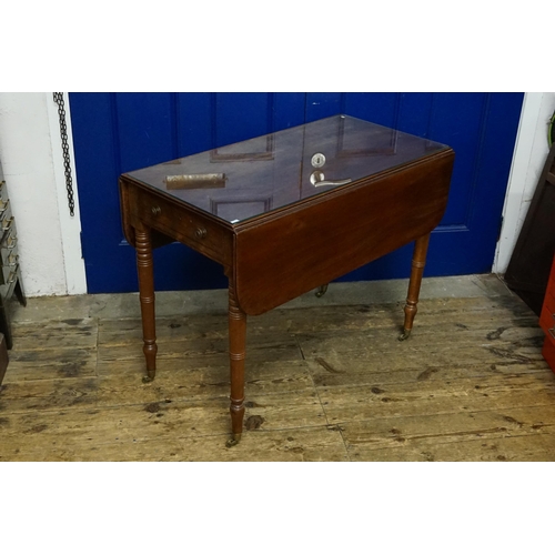 513 - A Georgian Mahogany Drop Flap Pembroke Table fitted with a single drawer, resting on turned legs & B... 