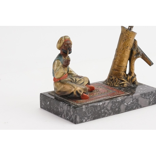 657 - An Austrian painted Table Lighter designed as an Arab on a Carpet on a Marble base.