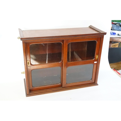 525 - A Mahogany Double Sliding Doored Glass Cabinet. Measuring: 61cms across x 47cms high x 25cms deep.